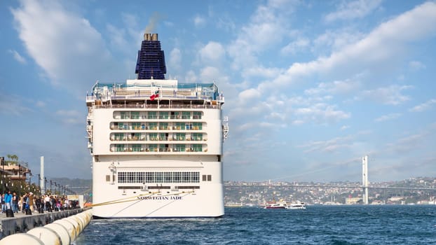 Istanbul, Turkey - May 7, 2023: Norwegian Jade, Large cruise ship docked at terminal of Galataport, a mixed use development located along shore of Bosphorus, with Bosphorus Bridge in the background