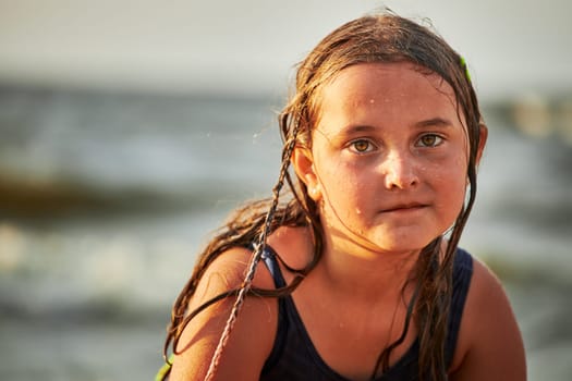 Portrait of little girl playing in the sea. Child wearing swimsuit enjoying summer vacation on the beach. Travel concept