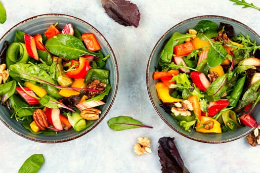 Tasty salad bowl with pepper, rhubarb, nuts and lettuce.