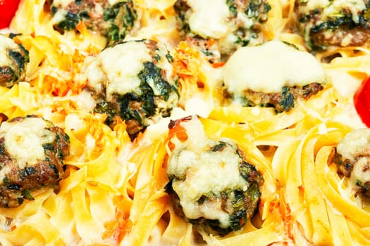 Meatballs served over appetizing noodles in baking dish. Italian food.