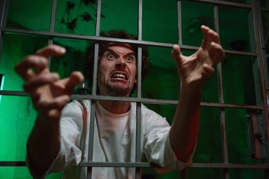 Mentally unstable male patient with attack of rabies locked in cage ward. Psychiatric department in clinic and mad people treatment