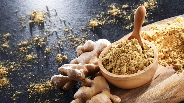 A bowl with ground ginger and its fresh rhizome.