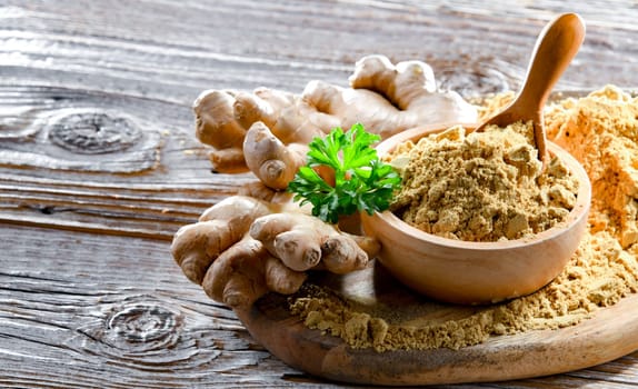 A bowl with ground ginger and its fresh rhizome.