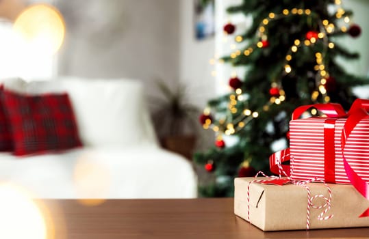 Christmas, New Year background with copy space for design. Empty wooden tabletop surface, blurred Christmas fir tree composition, bokeh sparkle lights effect. Mockup ready for product montage