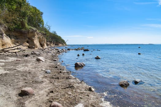 Island Poel on the steep coast to the Baltic Sea. Break-off edge with tree on the slope. Coastal landscape in summer. Vacation resort
