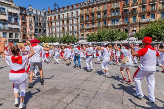 Pamplona, Spain: 09 July 2023: People celebrate San Fermin festival in traditional white abd red clothing with red necktie, Pamplona, Navarra, Spain.