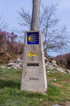 Yellow scallop shell, touristic symbol of the Camino de Santiago showing direction on Camino Norte in Spain.Column with rocks signing the way to Santiago De Compostela on the St James pilgrimage route
