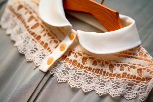 Close-up of the collar of the lace dress on a wooden hanger. Handmade embroidery pattern. Dress for a girl. AI generated