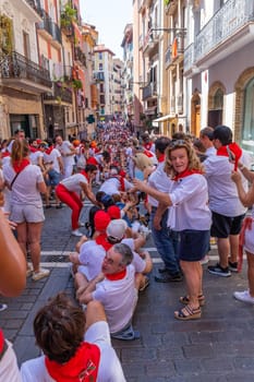 Pamplona, Spain: 09 July 2023: People celebrate San Fermin festival in traditional white abd red clothing with red necktie, Pamplona, Navarra, Spain.