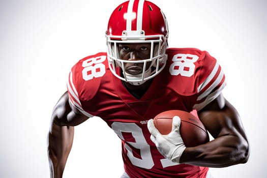 Portrait of American football player in red jersey holding ball against white background.