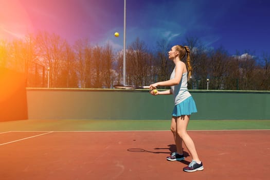 Sexy girl tennis player in white dress and heels holding tennis racket on the court. Young woman is playing tennis, sport