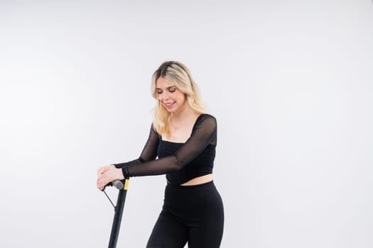 Blonde woman on a red and white background sit and stand with electro scooter and resting