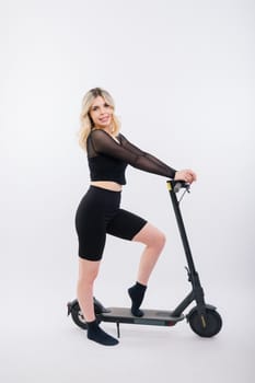 Blonde woman on a red and white background sit and stand with electro scooter and resting