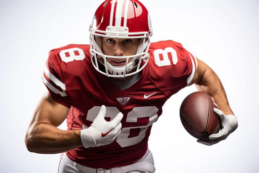 Portrait of American football player in red jersey holding ball against white background.