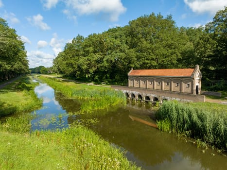 restored old weir with the name "schuivenhuisje"" built in 1887 on the Almelo-Nordhorn canal, province of Overijssel, the Netherlands"