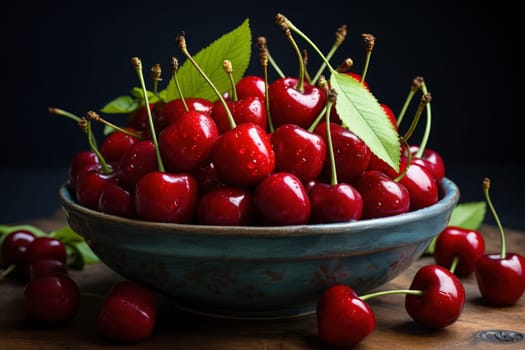 Ripe red cherries in a bowl and next to it on wooden table.
