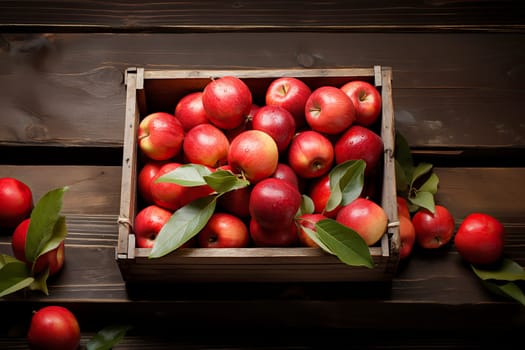 fresh red apples with leaves in a wooden box, top view.