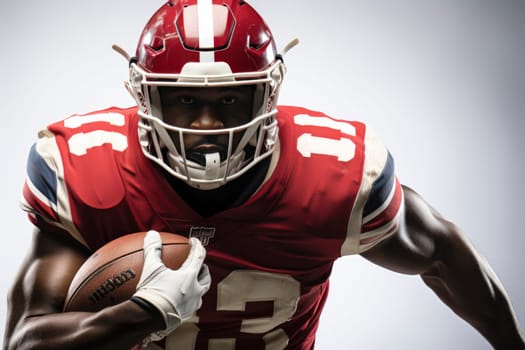Portrait of American football player in red jersey holding ball against white background.
