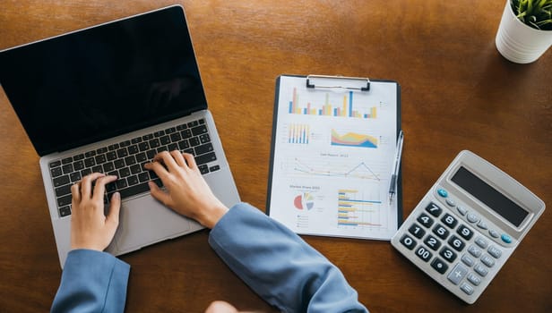 Businesswoman checking and analysing report, Accountant calculate financial report, top view business woman working on laptop computer with chart graphs and calculator, finance analysis concept