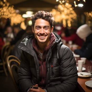cheerful man near a long table on Christmas Eve at the Christmas market. on a blurred background of long tables with treats on the holiday.