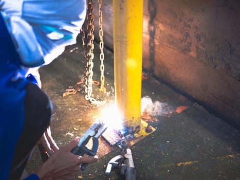 Industry worker welding steel structure at work background.