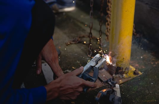 Industry worker welding steel structure at work background.
