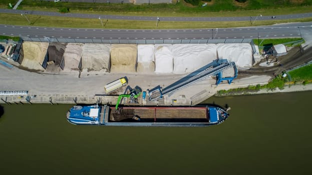 Loading barge with sand and rubble on a small berth. Freight transport logistics in the netherlands