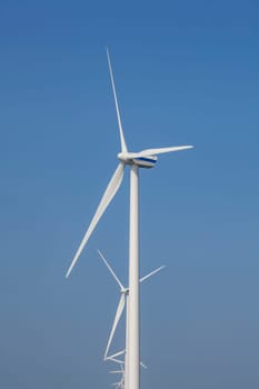 A Modern Wind Farm consisting of Wind Turbines with Two and Three Blades along the Shore of Grevelingenmeer under a Blue Sky in the Netherlands