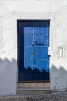 Vintage window and blue door on old traditional house in Andalusia, Spain