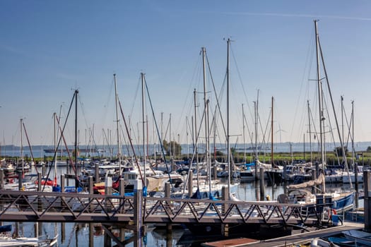 Sailboat harbor, many beautiful moored sail yachts in the sea port, modern water transport, summertime vacation, luxury lifestyle and wealth concept