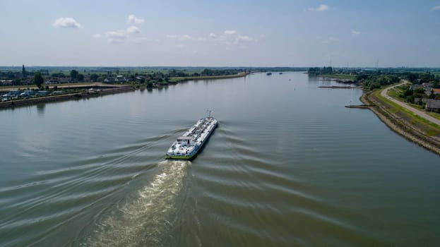 Aerial view:Barge with cargo on the river. River, cargo barge, highway with cars.. Cargo ship on the river
