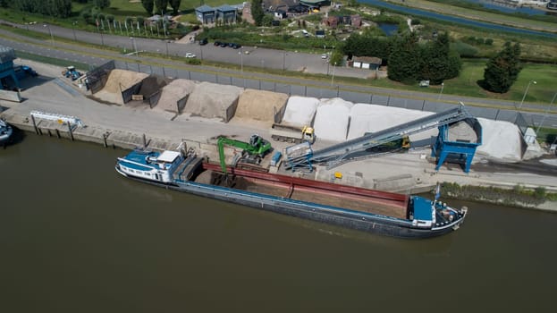 Loading barge with sand and rubble on a small berth. Freight transport logistics