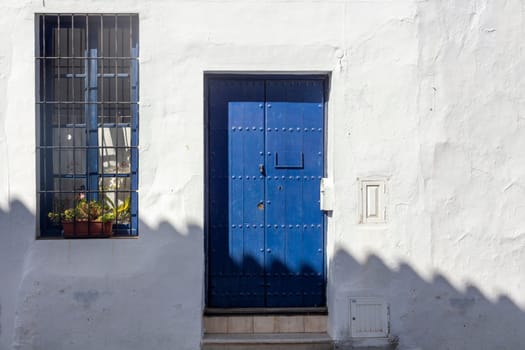 Vintage window and blue door on old traditional house in Andalusia, Spain