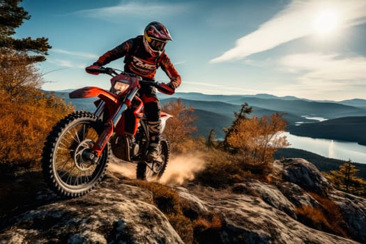 Professional motorcyclist in full moto equipment climbing rocky mountain top. Extreme rider on off-road cross enduro motorcycle with  beautiful mountains landscape down on background, with autumn forest and lake. AI generated