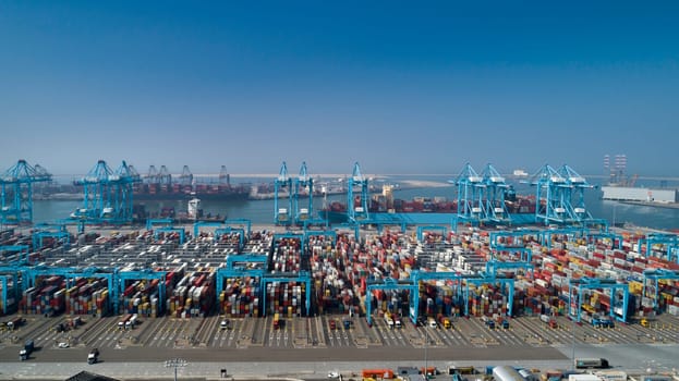 Large harbor cranes loading container ships in the port of Rotterdam