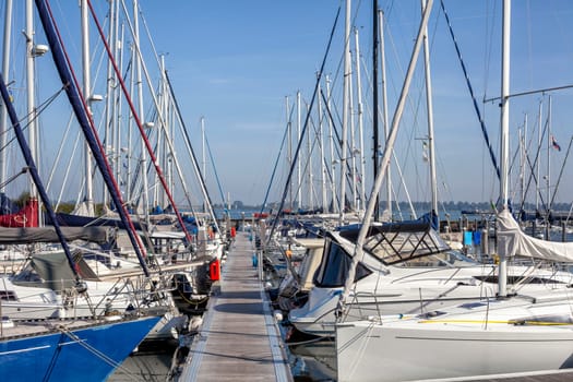 Sailboat harbor, many beautiful moored sail yachts in the sea port, modern water transport, summertime vacation, luxury lifestyle and wealth concept