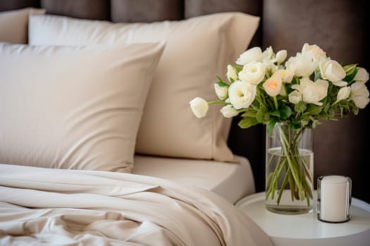 Flower vase on night table in a bright bedroom. Beautiful white roses in a vase on a table next to bed with gorgeous organic linens. AI generated
