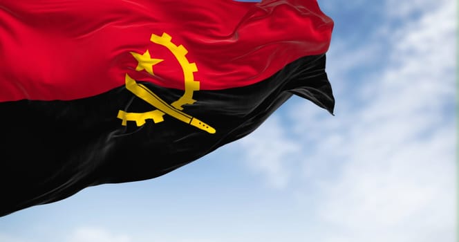 Angola national flag waving in the wind on a clear day. Two horizontal bands, red and black, with a yellow emblem in the center. 3d illustration render. Fluttering fabric background