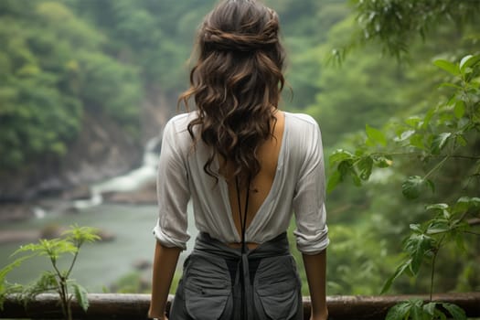 Close-up rear view of a brunette woman with a shiny wavy long hairstyle against the backdrop of a river in a nature reserve.