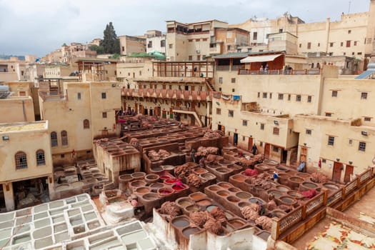 Men working hard in Chouara tannery souk in Fez, Morocco. The tannery souk of weavers is the most visited part of the 2000 years old city. Africa
