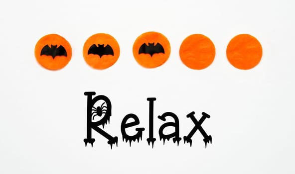 White Halloween Background With Orange Dots And Black Bats And Text Relax
