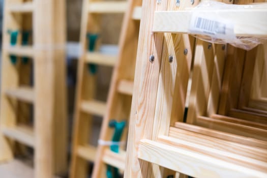 Many Wooden ladders. Stack of wooden stairs in the store.