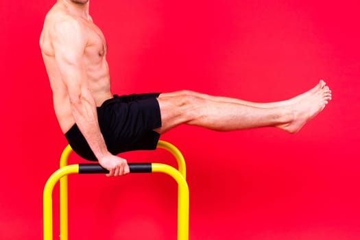 Front and side view photo of strong young man exercising on parallel bars in studio.