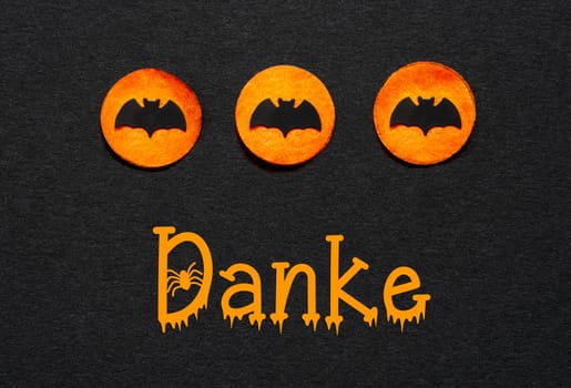 Black Halloween Background With Three Orange Dots With Bats And German Text Danke, Which Means Thanks In English