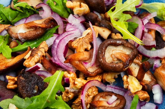 Diet salad with grilled forest mushrooms, onions, green and walnuts. Top view, copy space.