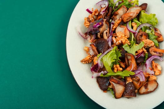 Diet salad with grilled forest mushrooms, onions, green and walnuts. Top view, copy space.