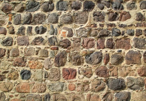 Texture of a wall built on many fieldstones.