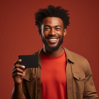 Young cheerful african american man holding black mockup for text in hand on red background.Generative AI