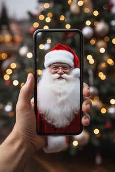 A hand holds a black smartphone with Santa Claus on the screen on a Christmas background.Generative AI