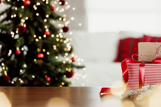 Christmas, New Year background with copy space for design. Empty wooden tabletop surface, blurred Christmas fir tree composition, bokeh sparkle lights effect. Mockup ready for product montage